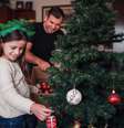 Pai e filha montam árvore de Natal; momento da montagem costuma ser uma tradição familiar  Foto: iStock