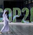 Homem passa na frente de letreiro com os dizeres COP28  Foto: Reuters / BBC News Brasil