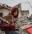 Criança recolhe lenha nos prédios destruídos em Gaza  Foto: Getty Images / BBC News Brasil