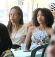 Imagem mostra duas mulheres negras observando atentamente um interlocutor enquanto há outras mulheres em volta.  Foto: Alma Preta