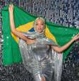 Imagem mostra Beyoncé com um vestido prateado e segurando a bandeira do Brasil.  Foto: Alma Preta