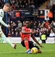  Foto:   Ben Stansall / AFP  via Getty Images - Legenda: Broja (à direita) tenta sair da marcação dupla da defesa do Luton Town para seguir levando o Chelsea ao ataque / Jogada10
