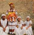 A imagem mostra quatro mulheres negras com vestimentas tradicionais africanas, em material de divulgação do Festival Agbado.  Foto: Alma Preta