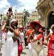 Imagem mostra pessoas em uma celebração religiosa na rua.  Foto: Alma Preta