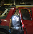 Policiais avaliam carro onde menina foi baleada  Foto: Reprodução/TV Globo
