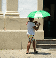 Mulher negra andando na rua durante forte onda de calor no Rio de Janeiro.  Foto: Alma Preta