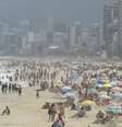 A imagem mostra uma praia do Rio de Janeiro cheia de banhistas na área e na areia.  Foto: Alma Preta