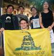 Membros do grupo Pibes Libertarios mostram uma bandeira de Gadsden, símbolo do libertarianismo  Foto: BBC News Brasil