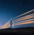 Torres de transmissão de eletricidade com fios laranjas brilhando contra o céu noturno  Foto: Artur Nichiporenko / iStock