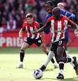 Foto:   Darren Staples / AFP Getty Images - Legenda:  Wissa, do Brentford (de vermelho e branco) recebe a carga de Disasi, do Chelsea   - / Jogada10