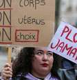 Manifestante segura cartazes que dizem 'Meu corpo, meu útero, minha escolha' e 'Nunca mais' durante protesto silencioso em apoio à revisão constitucional  Foto: Getty Images / BBC News Brasil