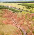 Imagem mostrando uma erosão em terra ao lado de uma rodovia.  Foto: FERNANDO MO / iStock