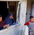 Palestinos olham destruição por janela de casa  Foto: Reuters / BBC News Brasil