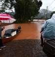 Pessoas resgatam seus pertences perto de área alagada próxima ao rio Taquari durante fortes chuvas na cidade de Encantado, no Rio Grande do Sul  Foto: REUTERS/Diego Vara