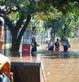 Pessoas carregam sacolas pelas ruas alagadas de Porto Alegre  Foto: Getty Images / BBC News Brasil
