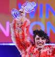 O cantor suíço Nemo com o belo troféu de cristal em formato de microfone antigo do Eurovision  Foto: Jens Büttner/picture alliance via Getty Images 