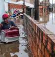 Homem deixa sua casa com gata de estimação no bairro Humaitá em Porto Alegre no domingo (12/5)  Foto: Sebastião Moreira/EPA-EFE/REX/Shutterstock / BBC News Brasil