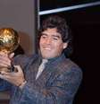  Foto: Pascal George/AFP via Getty Images - Legenda: Maradona posa para foto após receber a Bola de Ouro da Copa do Mundo de 1986 por sua atuação pela Argentina / Jogada10