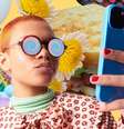Uma pessoa usando celular cercada por uma colagem que representa o conteúdo que consome nas redes sociais  Foto: Getty Images / BBC News Brasil