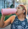 Mulher bebe água enquanto treina; higienizar garrafinhas com frequência é fundamental  Foto: LeoPatrizi/iStock