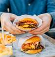 Dois hambúrgueres, com batata e refrigerante ao lado, uma combinação clássica e deliciosa.  Foto: Alexander Spatari / Getty Images