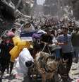 A group of Palestinians surrounded by destroyed buildings  Foto: Reuters / BBC News Brasil