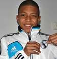 Ainda criança, Kylian Mbappé posa com uniforme do Real Madrid  Foto: Arquivo pessoal