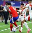 O chileno Dávila (de vermelho) recebe marcação dupla dos peruanos Quispe e Callens e tenta levar a melhor e partir para o ataque  Foto: Aric Becker/AFP via Getty Images / Jogada10
