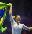 Rebecca Andrade comemora com a bandeira brasileira após conquistar a medalha de ouro durante a final individual individual feminina no Campeonato Mundial de Ginástica-Liverpool 2022.   Foto: Tim Clayton/Corbis via Getty Images