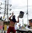 Um homem segura um tanque de metal enquanto moradores batem panelas para protestar contra os resultados das eleições depois que o presidente Nicolás Maduro e seu rival da oposição Edmundo Gonzalez reivindicaram a vitória na eleição presidencial de domingo, no bairro de Los Magallanes de Catia, em Caracas, Venezuela   Foto: REUTERS/Maxwell Briceno