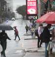 Pedestres enfrentam chuva e frio, com termômetros oscilando entre 16°C e 17°C graus, na manhã desta terça-feira (30/7), próximo à Estação de metrô do Brooklin, na zona sul de São Paulo.  Foto: RENATO S. CERQUEIRA/ATO PRESS/ESTADÃO CONTEÚDO