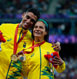 Gabriel Garcia e Jerusa Geber estão com a medalha de ouro no peito e seguram a Phryge, a mascota dos Jogos. Ele a abraça, vestindo uniforme amarelo, com detalhes em verde   Foto: Wander Roberto/CPB / Olimpíada Todo Dia