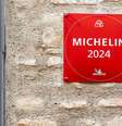 A foto mostra uma parede com uma placa vermelha escrito em branco "Michelin 2024".   Foto: Alamy / BBC News Brasil