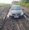 Ao tentar escapar de carro, suspeito acabou atolando na lama, o que o forçou a abandonar o veículo e seguir a pé   Foto: Divulgação/PM