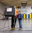 Um menino observa seu pai votando para a eleição presidencial dos EUA, no dia da eleição em Asheville, Carolina do Norte, EUA, nesta terça-feira, 5.  Foto: REUTERS/Jonathan Drake