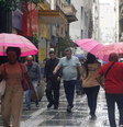 Pedestres se protegem da chuva na região central de São Paulo, na tarde desta quarta- feira, 6.  Foto: CRIS FAGA/DRAGONFLY PRESS/ESTADÃO CONTEÚDO