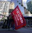 Uma pessoa segura uma bandeira em apoio a Donald Trump do lado de fora da Trump Tower, após a eleição de Donald Trump para presidente dos Estados Unidos, em Nova York. (6/11/2024)  Foto: REUTERS/Kent J. Edwards