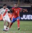  Foto: Daniel Apuy/Getty Images - Legenda: Vidal, do Chile (de vermelho) chega junto na marcação ao peruano Peña / Jogada10