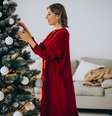 Mulher decorando árvore de Natal.  Foto: Freepik