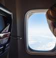 Mulher olhando a vista pela janela do avião.  Foto: Unsplash