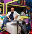 O apresentador Tadeu Schmidt na casa do BBB 22, sentado na sala  Foto: Divulgação/Globo / Caras Brasil