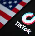 Um celular com logo do aplicativo do TikTok aberto em cima de uma bandeira dos EUA  Foto: Getty Images / BBC News Brasil