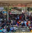 Migrantes aguardam em uma quadra de esportes por caravana com destino à fronteira norte entre Estados Unidos e México, na cidade de Huixtla  Foto: REUTERS/Raquel Cunha