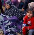 Uma mulher e uma menina no meio de um grupo de palestinos deslocados  Foto: Reuters / BBC News Brasil