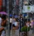 Uma mulher se refresca em uma fonte no centro de Porto Alegre, Brasil, em 15 de dezembro de 2023, quando uma onda de calor atingiu o Rio Grande do Sul,  Foto: Getty Images / BBC News Brasil