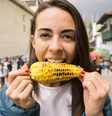 Mulher comendo um milho assado  Foto: Getty Images / BBC News Brasil
