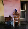 Uma mulher se refresca do lado de fora de sua casa durante a onda de calor em Guaratiba, no subúrbio do Rio de Janeiro, nesta segunda-feira, 17  Foto: REUTERS/Tita Barros