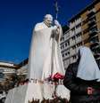 Uma estátua do falecido Papa João Paulo 2º fica do lado de fora do Hospital Gemelli, onde o Papa Francisco está recebendo tratamento médico  Foto: Reuters / BBC News Brasil