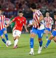  Foto: Carlos Parra/FFCh - Legenda: Jogadores de Paraguai e Chile em disputa de bola no Defensores del Chaco, em Assunção / Jogada10