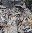 Palestinos se reúnem enquanto equipes de resgate procuram vítimas sob os escombros de uma casa atingida por um ataque israelense, em meio ao conflito entre Israel e o Hamas, no campo de refugiados de Nuseirat, no centro da Faixa de Gaza. 14/05/2024  Foto: Ramadan Abed/Reuters
